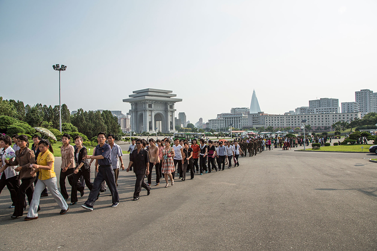It’s a flashmob, NoKo style. When I arrived nearly anywhere in Noko—here at one of Pyongyang’s Funfairs (NoKo’s extraordinarily depressing amusement parks)—no one would be there. But within minutes of arriving, a HUGE swarm of people of people would arrive walking in lockstep four or five people across. The Arch de Triumph can be seen in the background, as can the Ryugyong Hotel.