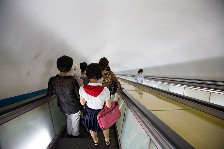 Descending into the Pyongyang Metro, reportedly one of the deepest metros in the world. Rumors persist that the Pyongyang Metro doubles as giant bomb shelter, linking vast underground military installations to one another, with secret lines just for the government, and escape tunnels to China. Rumors also persist that “normal” people actually use it.
